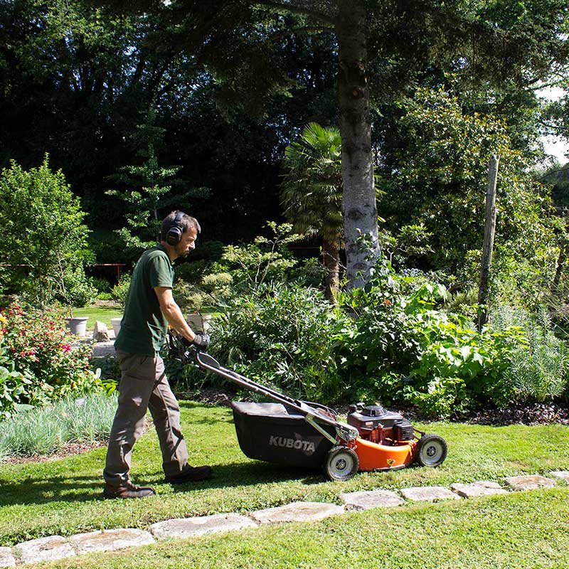 Un jardinier AMPER tond la pelouse